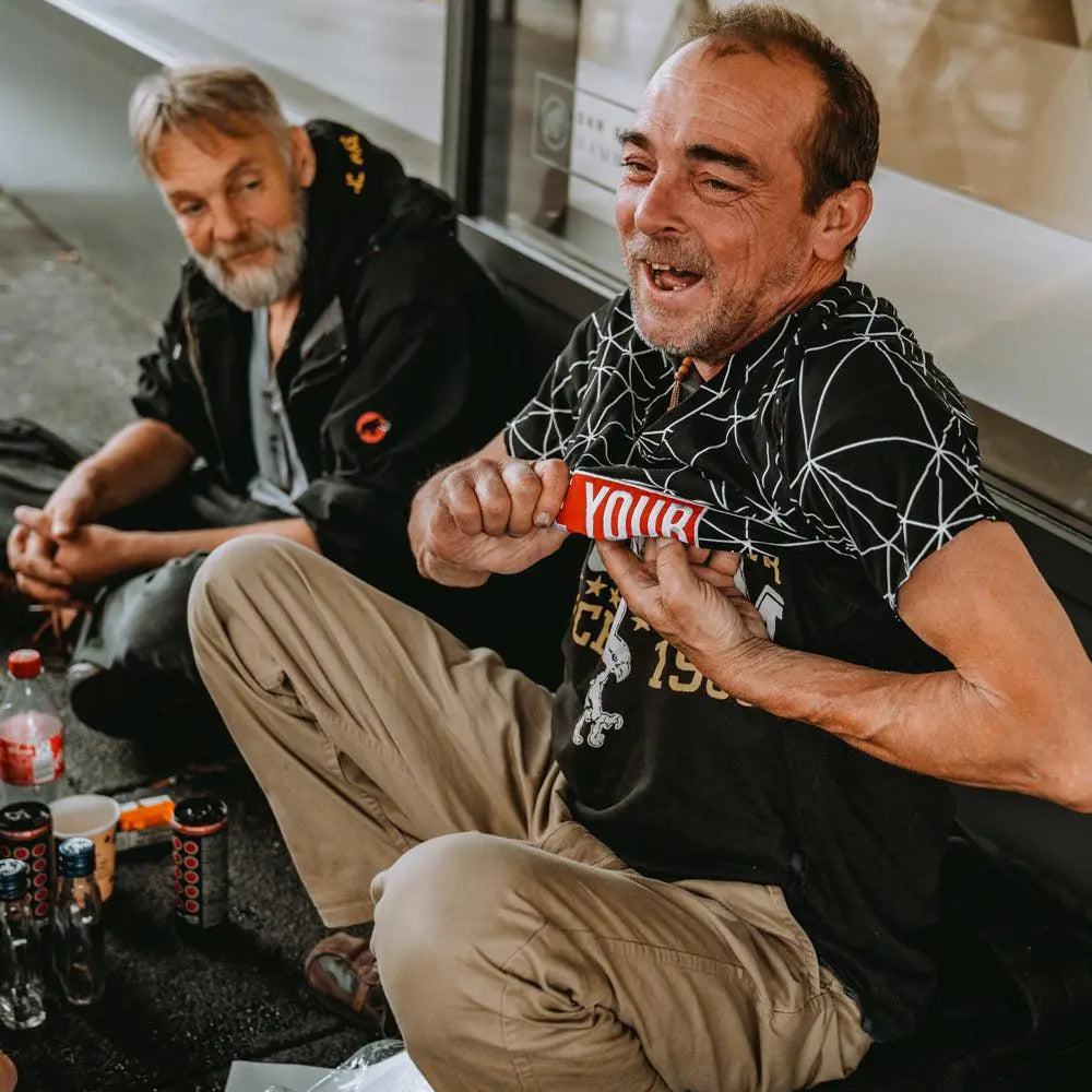Ein Mann auf der Strasse freut sich über ein Geschenk